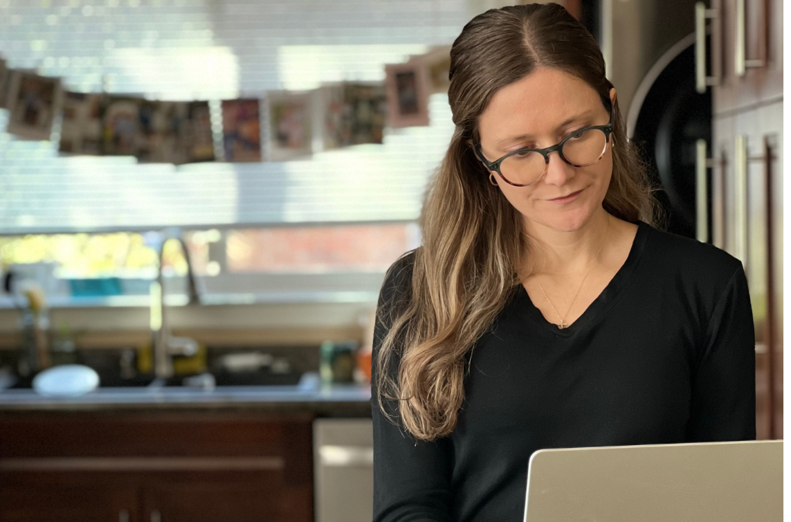 woman looking down at macbook