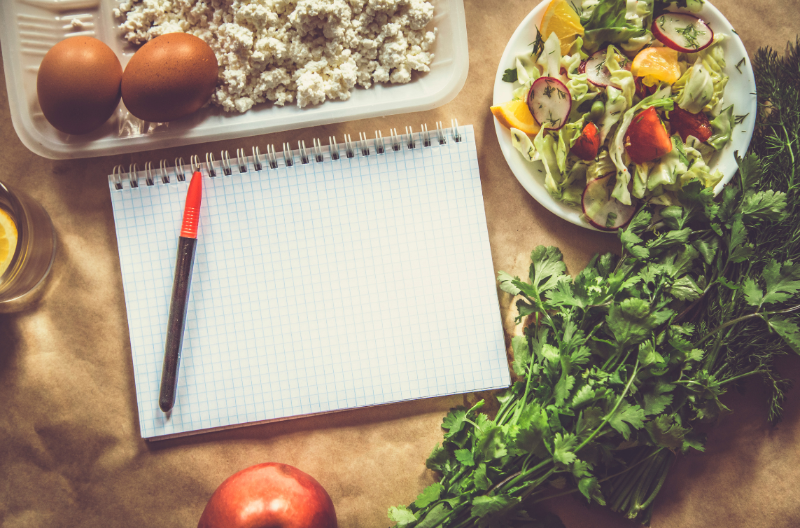 4 tips for family meals featured image blank writing pad with a pen surrounded by fresh ingredients