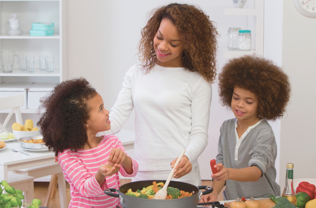 mother with her 2 school-aged children helping her cook