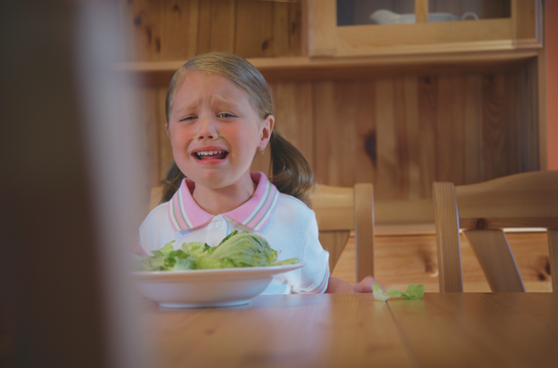 child upset about vegetables school aged child frustrated and upset looking at plate of vegetables